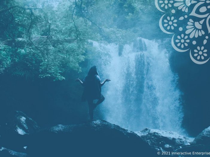 woman meditating in forest by a waterfall
